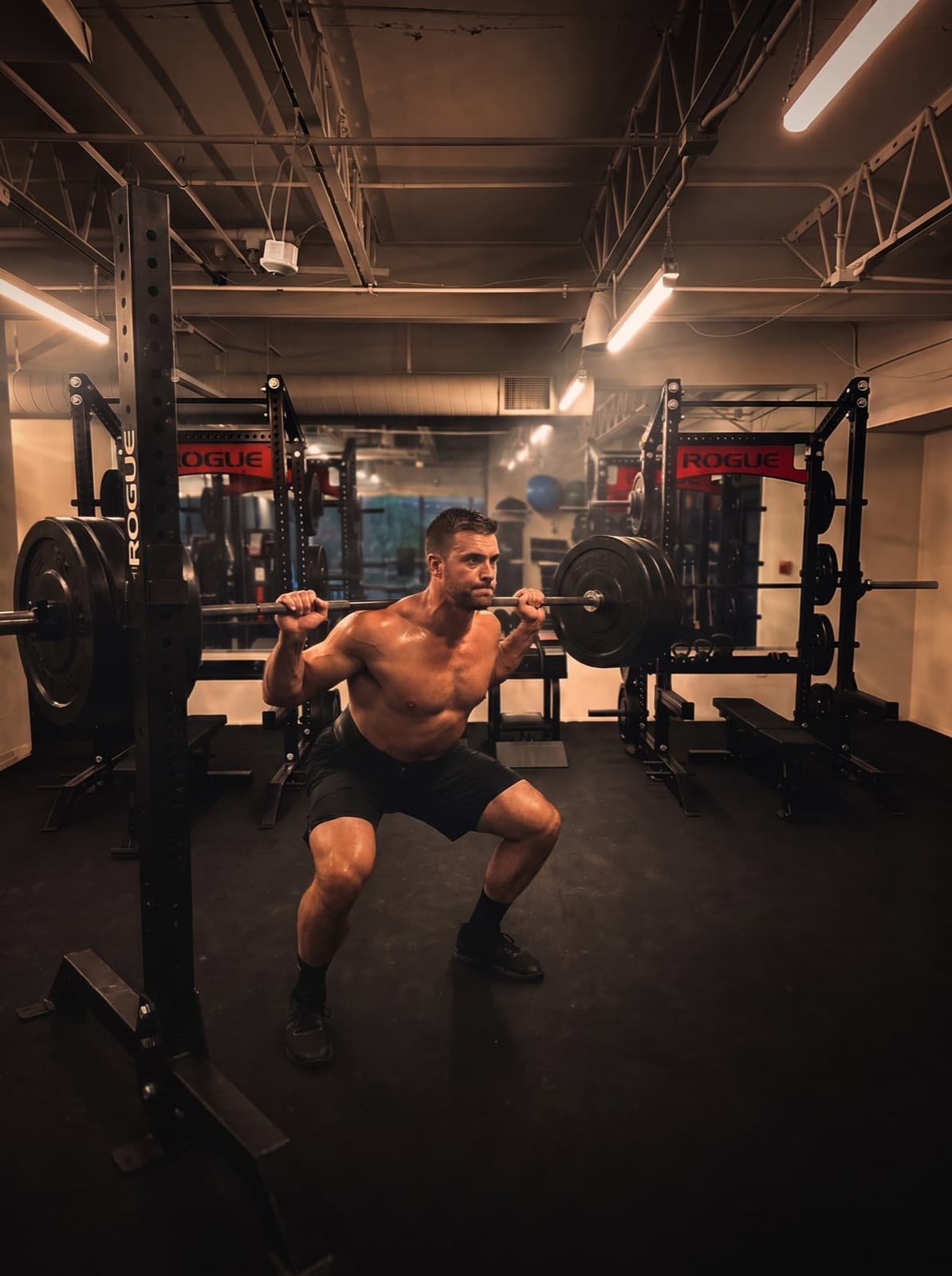 Athlete performing a barbell back squat in the rack